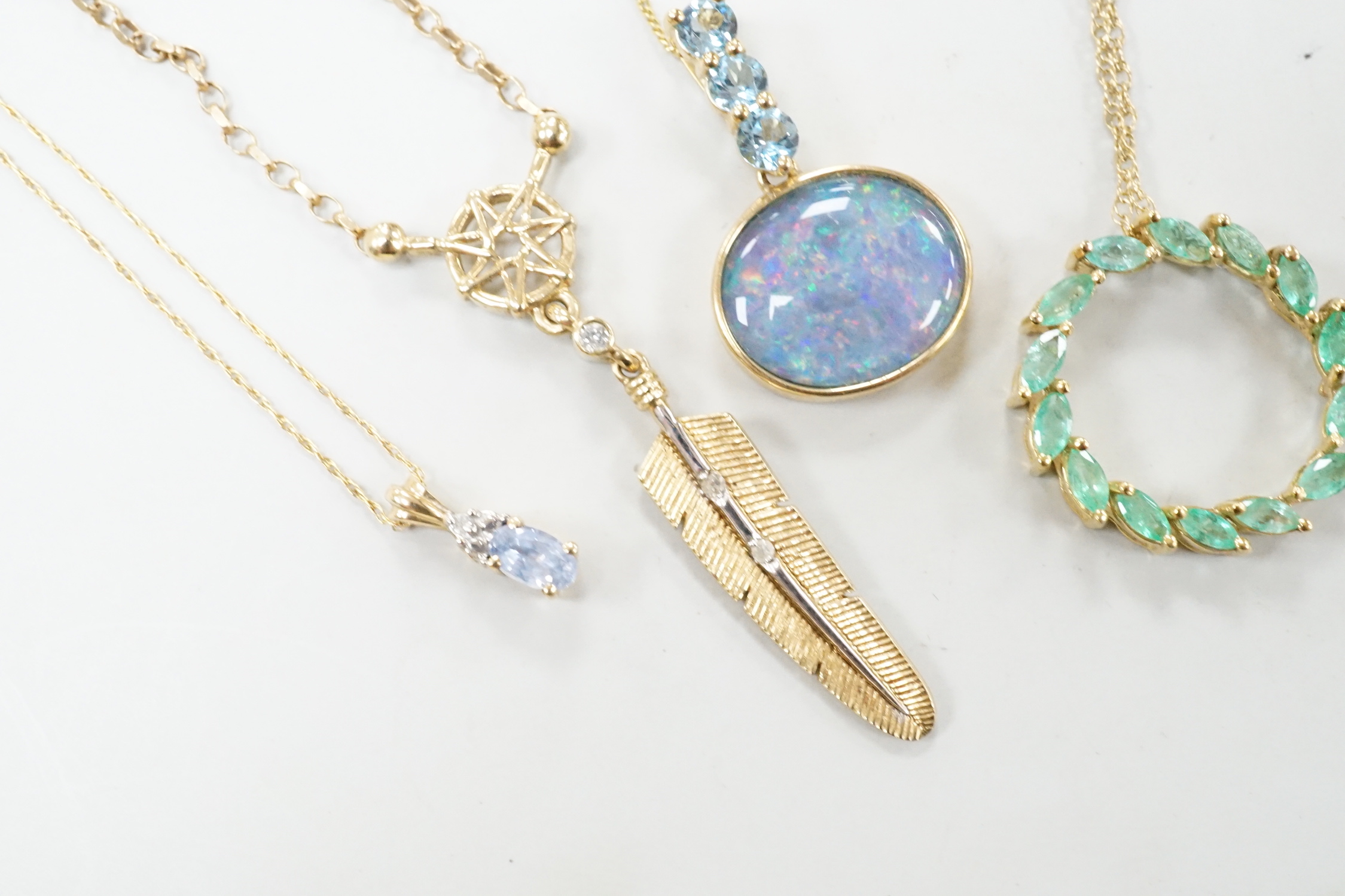 Three assorted modern 9ct or yellow metal and gem set pendants, on 9ct chains including opal doublet and blue topaz, feather shape and emerald set circular and a similar 10k pendant, on a 10k chain, longest 52cm, gross w